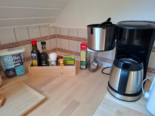 Kitchen Küchenbereich mit Kaffeemaschine, Gewürzen und einer Holzkiste für Vorräte.