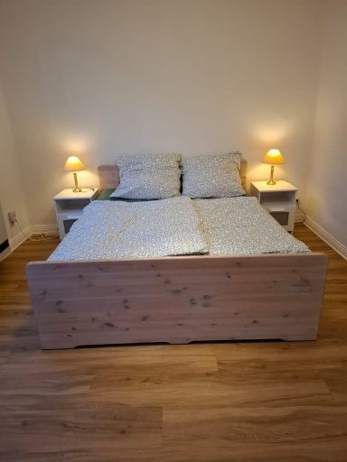 Master bedroom Doppelbett mit weißen Kissen, Nachttischen und Beleuchtung in einem hellen Raum.